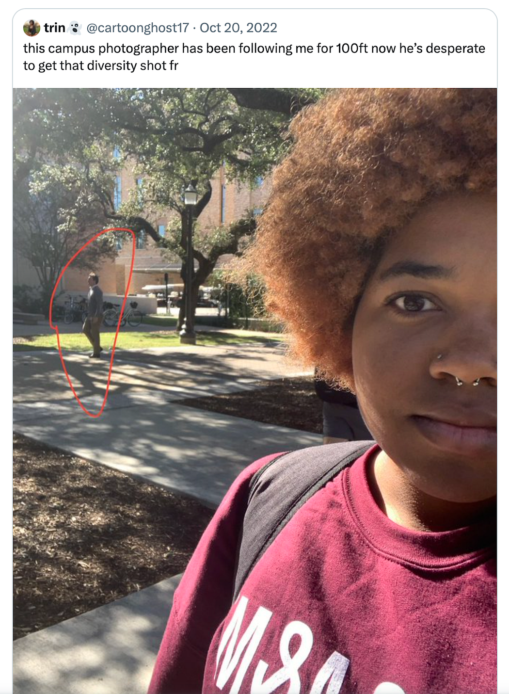 Black student wearing burgundy Texas A&M sweatshirt points out photographer behind them while they navigate campus. Tweet accompanying the photo says: “this campus photographer has been following me for 100ft now he’s desperate to get that diversity shot fr”