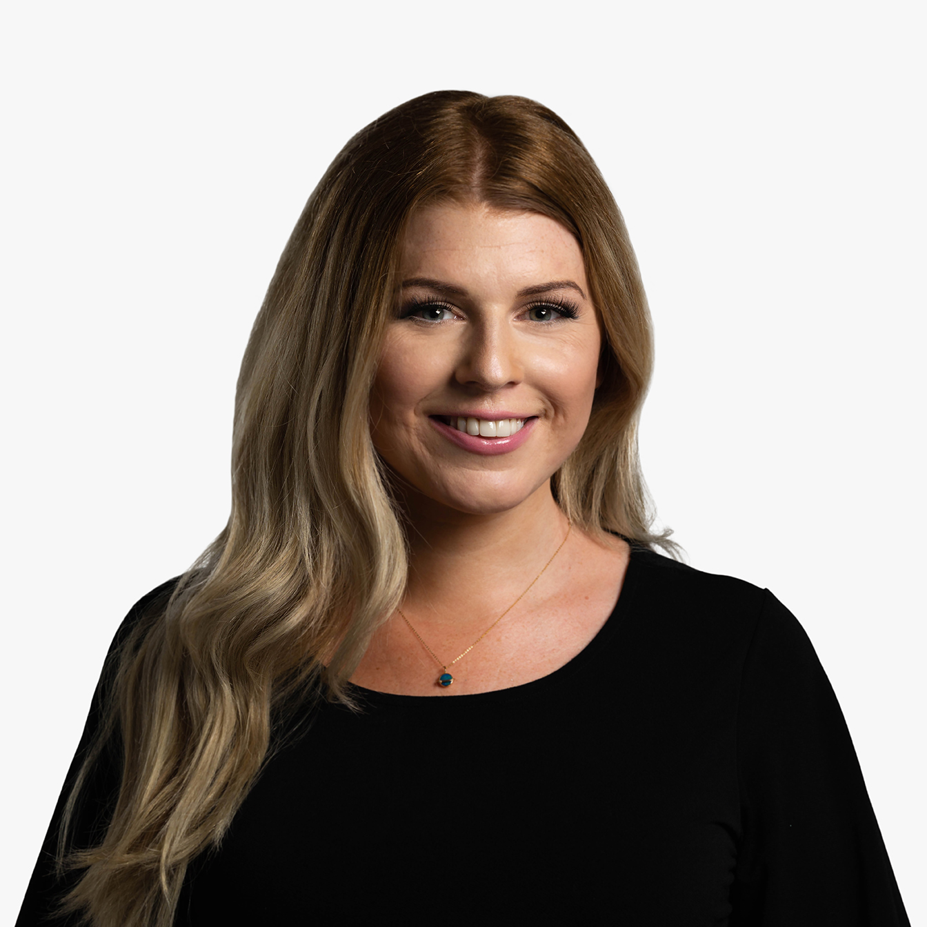 Charlotte Hess, a white woman in her mid-thirties with long, reddish blonde hair and blue eyes, wearing a black top, looking off to her left and smiling.