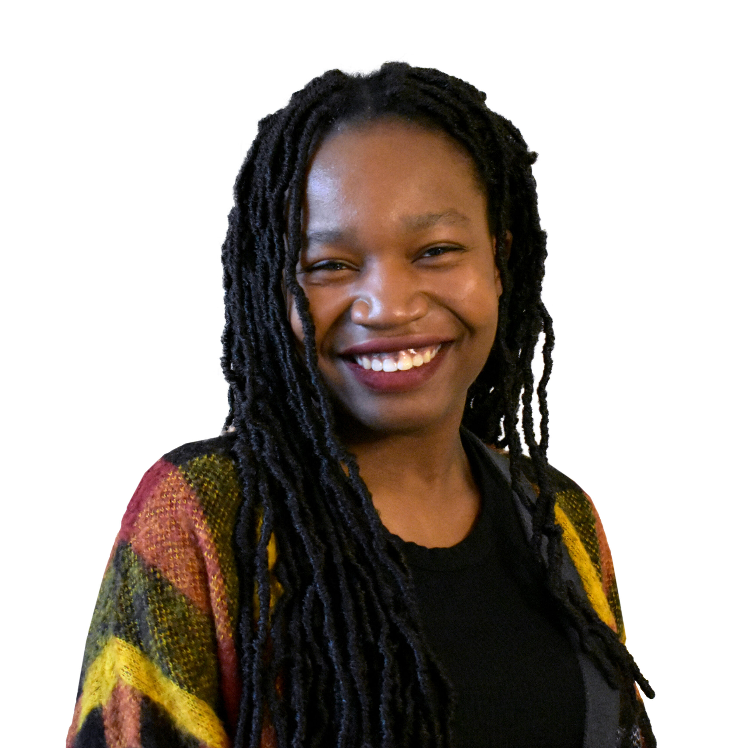 Amaka Mgboji, a young Black woman, with braids, wearing a colourful cardigan over a black tee.